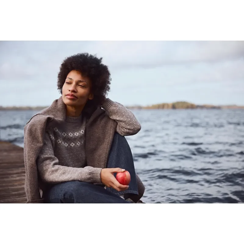 Dame im grauen Wollpullover am Wasser