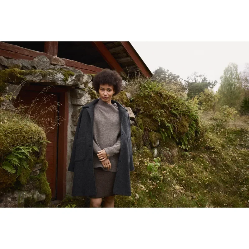 Dame in dunkler Naturmode in ländlicher Umgebung