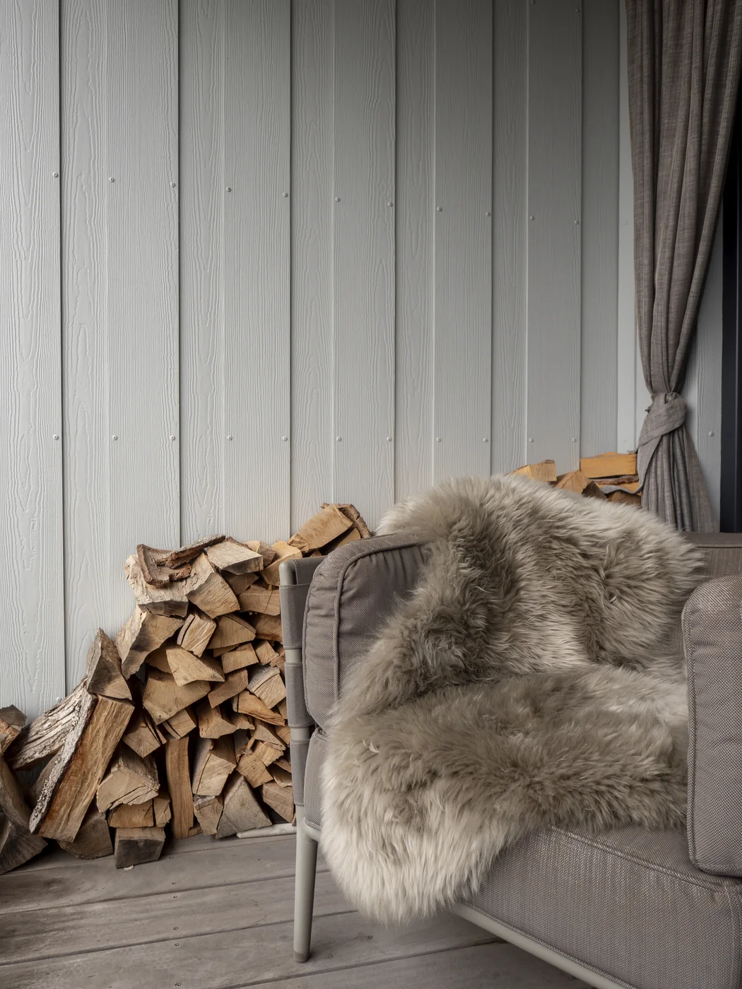 Graues Schaffell am Kaminholz