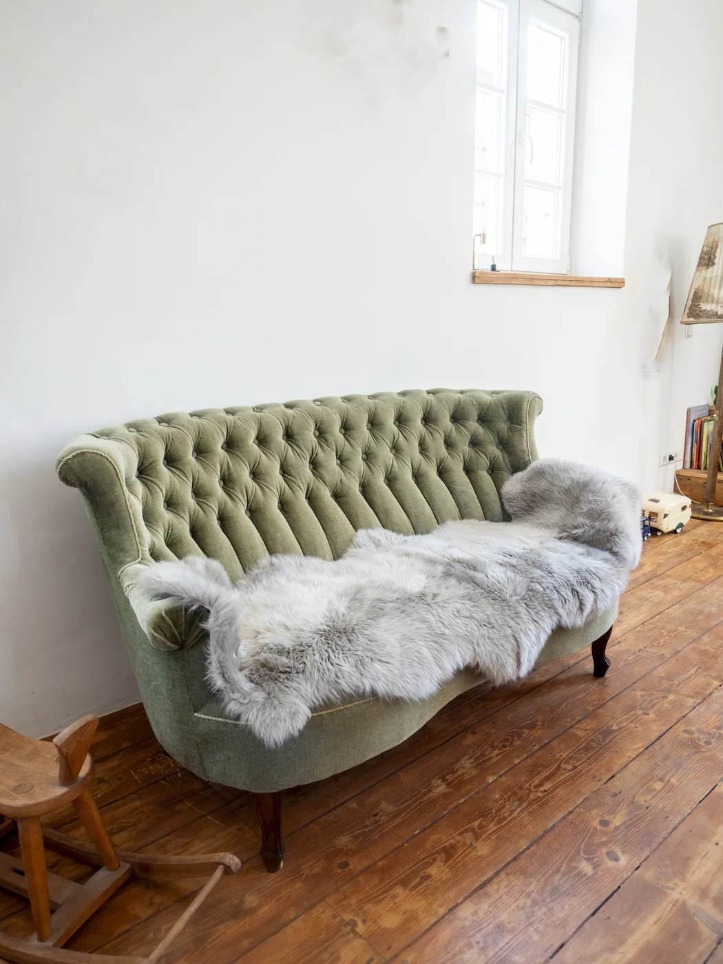 Großes Schaffell auf einem grünen Sofa