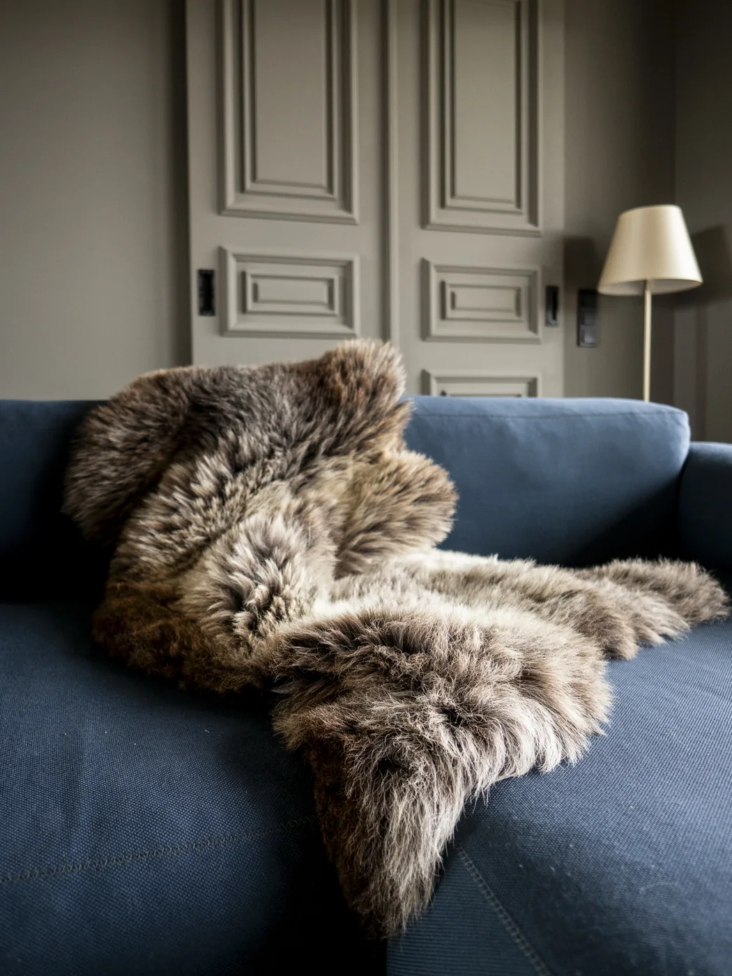 Englisches Lammfell auf einem blauen Sofa